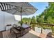 Outdoor deck featuring a dining table, bench seating, striped umbrella, and decorative potted plants at 476 Springer Nw Bnd, Marietta, GA 30060