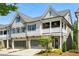 Charming townhome featuring a two-car garage, stone accents, a covered porch, and manicured landscaping at 476 Springer Nw Bnd, Marietta, GA 30060