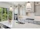 Close-up of the kitchen island featuring white countertops, gray cabinets, and stainless steel appliances at 476 Springer Nw Bnd, Marietta, GA 30060