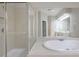 Large bathroom featuring a glass-enclosed shower, soaking tub, and expansive mirror, creating a luxurious retreat at 478 Vinings Estates Se Dr # B02, Smyrna, GA 30126
