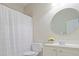 Bright bathroom featuring a white sink and cabinet, a round mirror, and a shower with a white curtain at 478 Vinings Estates Se Dr # B02, Smyrna, GA 30126