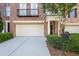 Paved driveway leads to an attached two-car garage with a neatly trimmed shrub border at 478 Vinings Estates Se Dr # B02, Smyrna, GA 30126