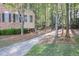 A view of the home's exterior with a brick facade and a driveway leading through trees at 478 Vinings Estates Se Dr # B02, Smyrna, GA 30126