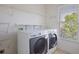 White laundry room featuring washer, dryer, shelving and bright window at 478 Vinings Estates Se Dr # B02, Smyrna, GA 30126