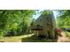 View of the home's rear exterior featuring a wooden deck and mature trees offering ample backyard shade at 728 Brittany Ct, Stone Mountain, GA 30083