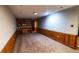 Basement area with built-in shelves, paneled walls, and neutral carpet at 728 Brittany Ct, Stone Mountain, GA 30083