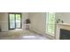 Cozy living room with a fireplace, sliding glass doors to the backyard, and natural light from the large window at 728 Brittany Ct, Stone Mountain, GA 30083