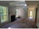 Bright living room with a fireplace, beams, and large windows offering ample natural light and an open staircase at 728 Brittany Ct, Stone Mountain, GA 30083