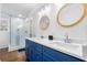 Bright bathroom with blue vanity, double sinks, modern fixtures, and glass-enclosed shower at 3180 Spring St, South Fulton, GA 30349