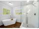 Modern bathroom featuring a soaking tub, walk-in shower, and wood look flooring at 3180 Spring St, South Fulton, GA 30349