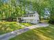 Charming two-story white home with a spacious front yard and a long driveway, surrounded by mature trees at 3180 Spring St, South Fulton, GA 30349