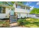 Charming two-story home with a brick facade, wooden shutters, landscaped yard, and a welcoming light blue front door at 3180 Spring St, South Fulton, GA 30349