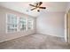 Inviting bedroom featuring large windows, ceiling fan, and plush carpet at 1310 Kilmington Ct, Alpharetta, GA 30009