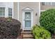 Close-up of the light blue front door with sidelight and steps, accented by lush, mature landscaping at 1310 Kilmington Ct, Alpharetta, GA 30009