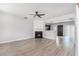 Open-concept living room with fireplace, ceiling fan, and a view to the kitchen with stainless appliances at 1310 Kilmington Ct, Alpharetta, GA 30009