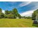 Expansive backyard with lush green grass, mature trees, and a small outbuilding, perfect for outdoor activities at 472 Linda Ln, Powder Springs, GA 30127