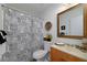 A cozy bathroom includes a toilet, shower curtain with skyscraper print, and a wooden vanity at 472 Linda Ln, Powder Springs, GA 30127