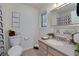 A well-lit bathroom features a gray vanity, decorative mirror, art prints and a patterned shower curtain at 472 Linda Ln, Powder Springs, GA 30127