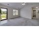 Bright living room featuring neutral carpeting, a front door entrance, and a view into an adjacent bathroom at 472 Linda Ln, Powder Springs, GA 30127