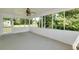 An enclosed porch features a swing, white paneling, and large windows showcasing scenic views at 472 Linda Ln, Powder Springs, GA 30127