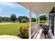 Covered porch with a black metal table and chairs, lantern style light fixture and view of the front yard at 472 Linda Ln, Powder Springs, GA 30127