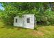Backyard outbuilding surrounded by green grass and mature trees at 472 Linda Ln, Powder Springs, GA 30127