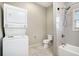 Efficient bathroom with stacked washer/dryer, tiled shower, toilet, and vanity at 953 Michigan Ave, Atlanta, GA 30314