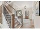Grand staircase with hardwood steps, black iron railings, and a view of the open-concept living space at 3345 Hillshire Dr, Cumming, GA 30028