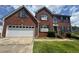 Traditional two-story brick home with an attached two-car garage and well-manicured landscaping at 5704 Winchester Pl, Lithonia, GA 30038