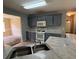 An outdated kitchen features stainless steel sink, standard appliances, and gray cabinetry at 5704 Winchester Pl, Lithonia, GA 30038