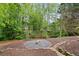 Outdoor space with firepit and landscaping in a serene wooded setting at 681 Braidwood Nw Ter, Acworth, GA 30101