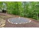 Outdoor firepit area with stone and mulch in wooded backyard space at 681 Braidwood Nw Ter, Acworth, GA 30101