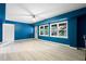 Spacious finished basement featuring a bright blue accent wall, white trim, and large windows with wooded views at 681 Braidwood Nw Ter, Acworth, GA 30101