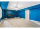 Nicely finished basement with light wood-look floors, bright blue walls, recessed lighting, and a classic console table at 681 Braidwood Nw Ter, Acworth, GA 30101