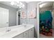 Bathroom with dual sinks, large mirror, and shower with colorful ocean-themed curtain at 681 Braidwood Nw Ter, Acworth, GA 30101