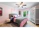Light-filled pink bedroom features hardwood floors, a cozy bed, and an elegant wardrobe at 681 Braidwood Nw Ter, Acworth, GA 30101