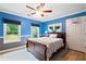 Bright bedroom with hardwood floors, ceiling fan, with blue accent wall and cow art at 681 Braidwood Nw Ter, Acworth, GA 30101