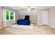 Bonus room features plush blue sofa, large window, and light, wood-look floors at 681 Braidwood Nw Ter, Acworth, GA 30101