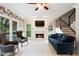 Bright living room features a fireplace, plush seating, and staircase at 681 Braidwood Nw Ter, Acworth, GA 30101