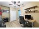 Bright office space with wood-look floors, floating shelves, ceiling fan, desk and modern computer equipment at 681 Braidwood Nw Ter, Acworth, GA 30101