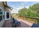 Back deck with wood railings, comfortable seating, and scenic views of the forest at 8090 Tristan Way, Whitesburg, GA 30185