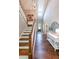 Bright entryway with wood staircase, hardwood floors and a transom window above the front door at 8090 Tristan Way, Whitesburg, GA 30185