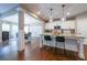 Open kitchen with island, granite countertops, pendant lighting and hardwood floors at 8090 Tristan Way, Whitesburg, GA 30185