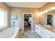 Bright, open main bathroom has a bathtub and a view into the main bedroom at 8090 Tristan Way, Whitesburg, GA 30185