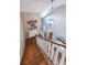 A well lit wooden staircase with modern light fixture and wall art at 8090 Tristan Way, Whitesburg, GA 30185