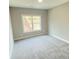 This bedroom has neutral paint, plush carpeting and a large window at 3355 Hillshire Dr, Cumming, GA 30028
