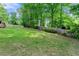 Spacious, green backyard featuring a grass lawn, mature trees, and a wood fence for privacy at 706 Briarleigh Sw Ct, Mableton, GA 30126
