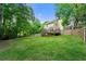 Green backyard with a wood fence, grass lawn, mature trees and view of the deck and house at 706 Briarleigh Sw Ct, Mableton, GA 30126