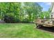 Large backyard with grass lawn, mature trees, deck with seating area, and wood fence at 706 Briarleigh Sw Ct, Mableton, GA 30126