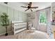 Bedroom features a crib, accent wall, a rocking chair with ottoman, soft rug and natural light at 706 Briarleigh Sw Ct, Mableton, GA 30126